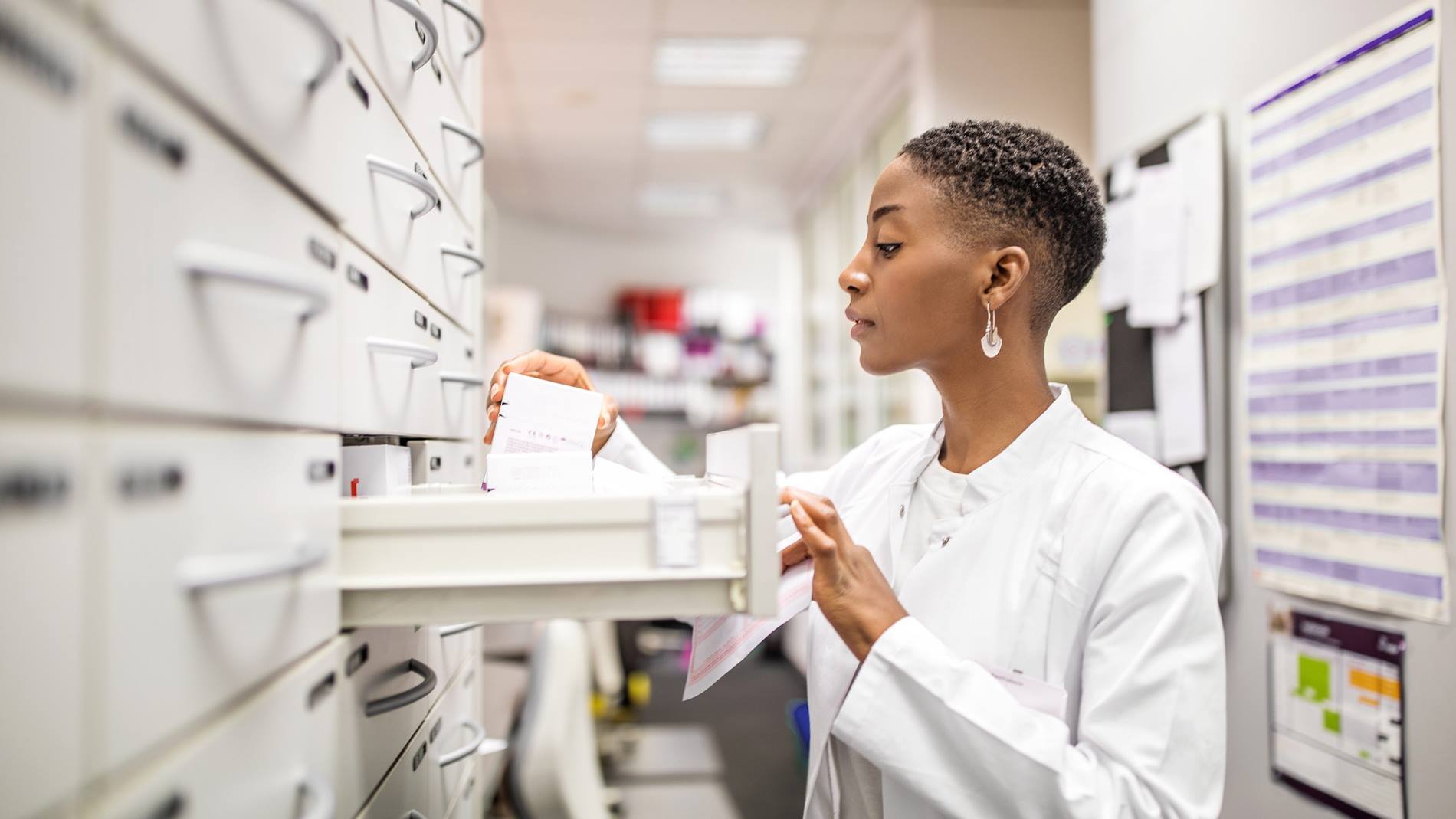 Apothekerin lagert Medikamenten in einer Apotheke