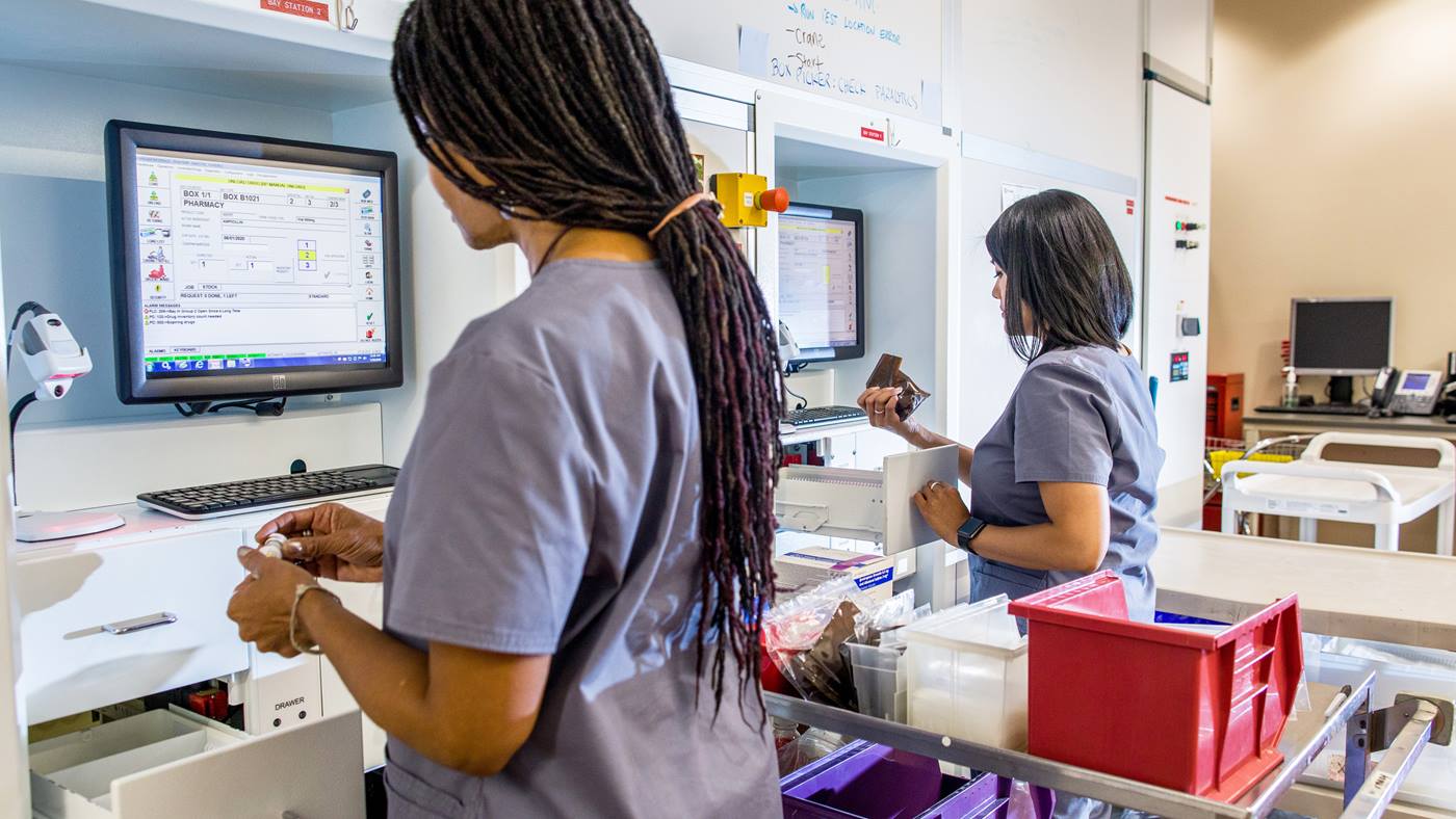 Pharmacy technicians using BoxPicker storage and retrieval system