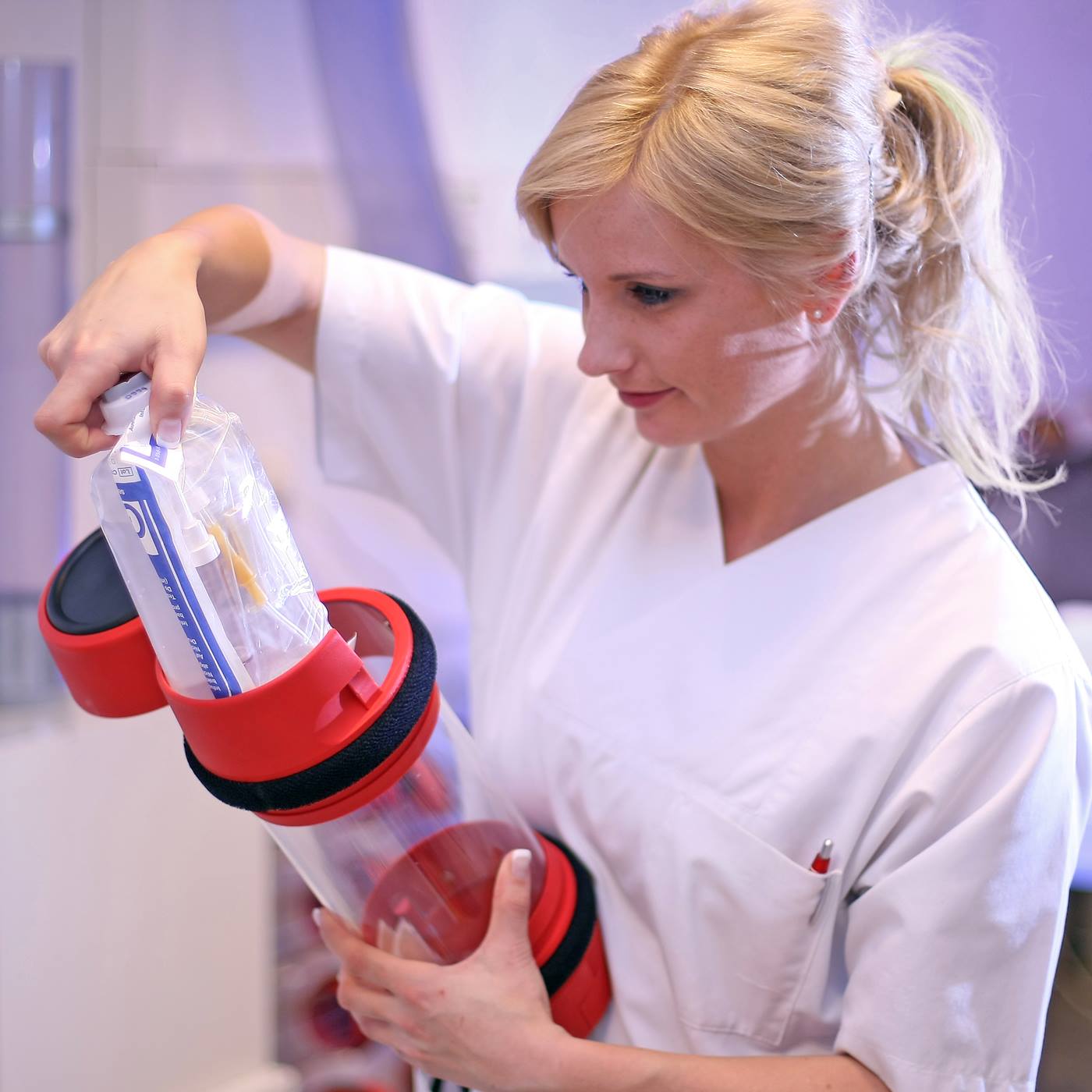 Medical staff fills carrier of pneumatic tube system